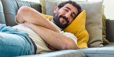Man enjoying alone time reclines on a sofa 