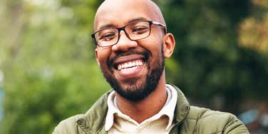 man with childlike joy on his face smiling at camera