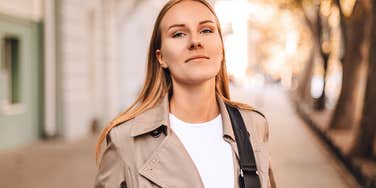 Woman with high self-esteem smiles confidently on a pretty street