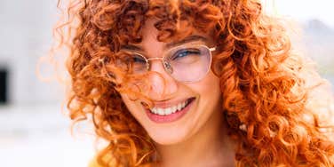Woman who has zero desire to impress anyone smiling warmly in the sun