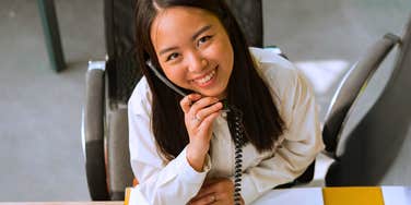 happy employee who loves her job talking on phone