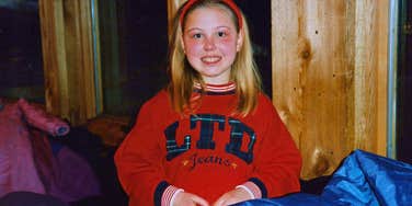 young millennial girl in the 1990s smiling innocently