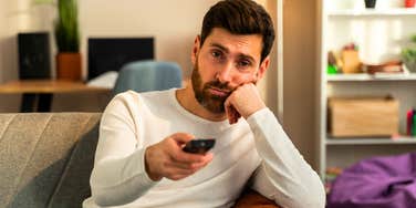broke man with too much time watching television being lazy