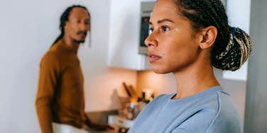 exhausted woman with lazy husband looking tired at home