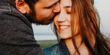 Eyes closed, she smiles into his kiss, the kind of unguarded tenderness that speaks for itself.