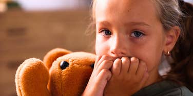 lonely little girl hiding how she feels at home