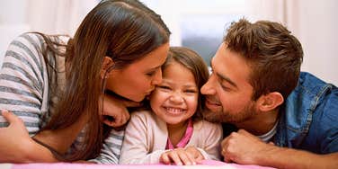 evolved nest parents giving their happy daughter affection