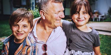 grandparent smiles with his happy grandkids