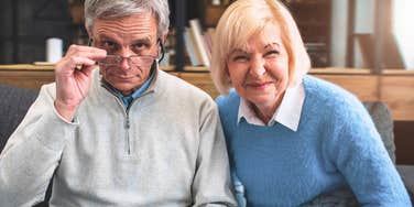 baby boomer couple with woman laughing and man looking like he thinks something's not funny 