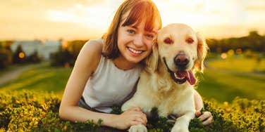 young woman smiling with her happy dog
