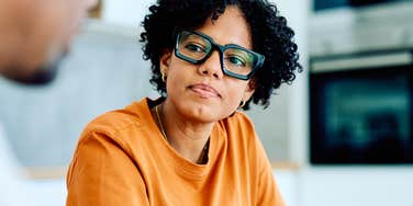 Woman who looks fatigued listening to a man talk