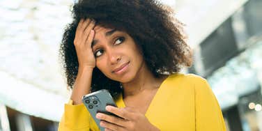Woman who seems worried looking up from her phone 