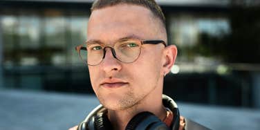 intelligent man in glasses looks at camera 
