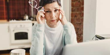 woman with low energy looks frustrated working at a computer