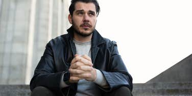 man looking stressed outdoors in an open space