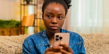 irritated annoyed woman reading text from friend canceling plans