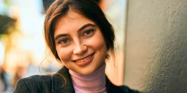 happy young woman smiling standing outside