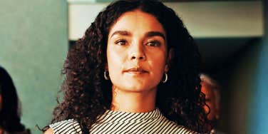 Confident woman with curly dark hair walking into a interview with resume. 