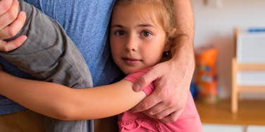 little girl hugging her overbearing parent