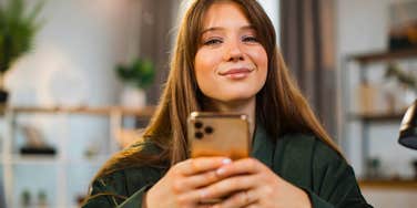 woman glued to her phone unable to leave the room without it