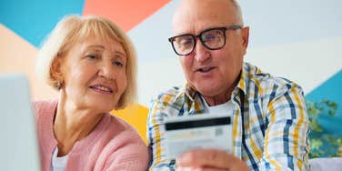 boomer couple looking at credit card spending money