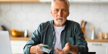 frustrated older man comparing costs from 10 years ago