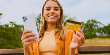 financially draining young woman holding credit card