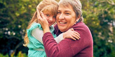 grandmother holding her daughter smiling hugging