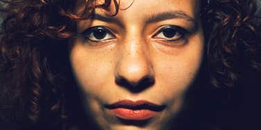self-pitying woman frowning in the dark close up