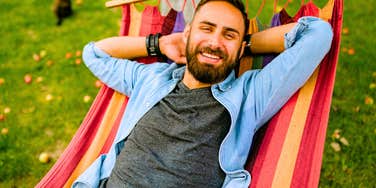 neurodivergent man resting and recharging in a hammock