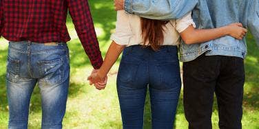 woman holding hands with two men