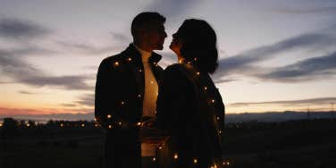 couple at night posing with fairy lights