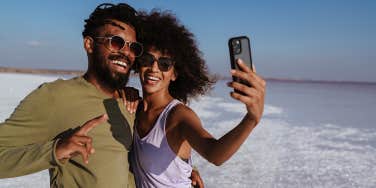 couple taking selfie by beach