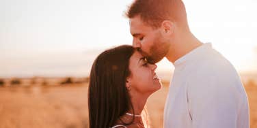 Man kisses girlfriend on forehead 