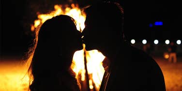 couple kissing in front of fire