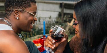 man and woman sharing drinks