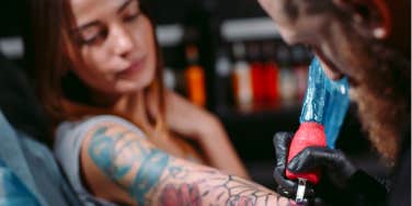 woman gets a tattoo at a tattoo shop