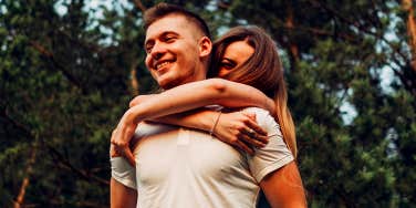 smiling couple with woman on man's back