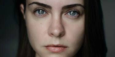 woman with dark hair staring directly at camera