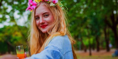 girl in flower crown holding man's hand