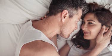 Overhead close up of young couple lying in bed together.
