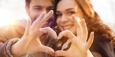 Closeup of couple making heart shape with hands