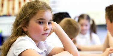 young girl sitting in classroom at school