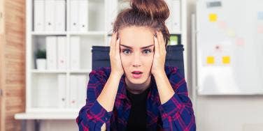 woman looking frustrated with head in her hands