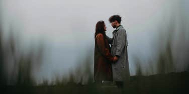man and woman standing together in moody weather