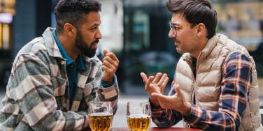two guy friends talking and enjoying drinks