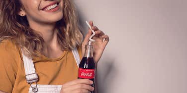 woman holding bottle of coke