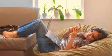 woman lying down with phone and laptop