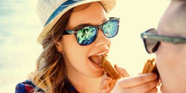 Woman and man feed each other snacks