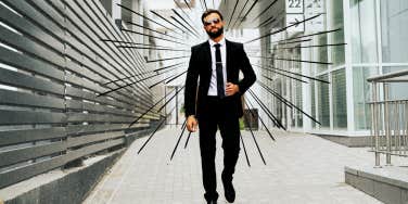 Man in suit walking away from buildings